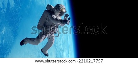 Female astronaut having a video call on her phone while performing space walk in open space, Earth in the background