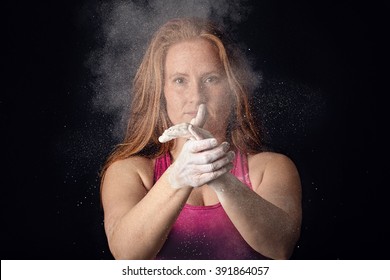 Female Athlete Applying Chalk To Hands. Strong Sports Woman Concept, Dark Gritty Style.