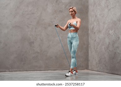 Female athlete bag jumping rope at gym. Young woman with skipping rope in gym. Strong caucasian boxer girl in sportswear jumping rope in gym. - Powered by Shutterstock