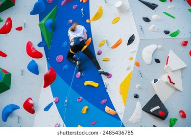 Female athlete climbs an artificial wall outdoors. Concept of extreme sports and bouldering - Powered by Shutterstock