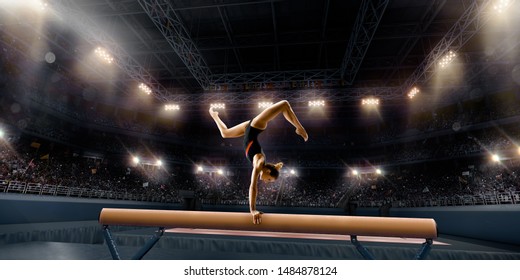 Female athlete doing a complicated exciting trick on gymnastics balance beam in a professional gym. Girl perform stunt in bright sports clothes - Powered by Shutterstock