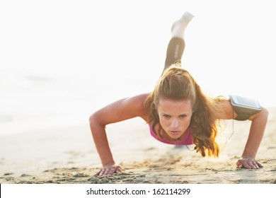 Female Athlete Doing Push Ups On Beach