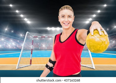 Female athlete with elbow pad holding handball against handball field indoor - Powered by Shutterstock