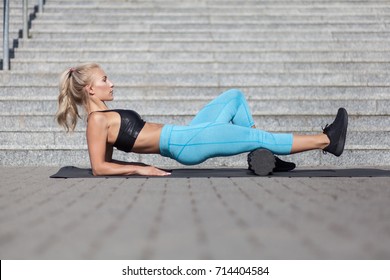 Female Athlete Exercising With Fascia Roll