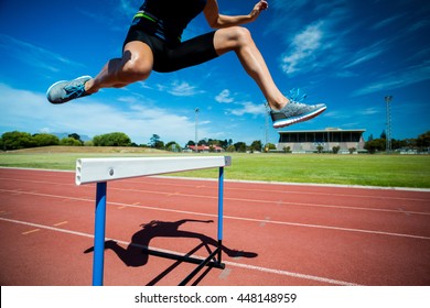 Female athlete jumping above the hurdle during the race - Shutterstock ID 448148959