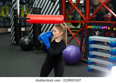 Female athlete practices punches on a simulator in the boxing ring. - Powered by Shutterstock