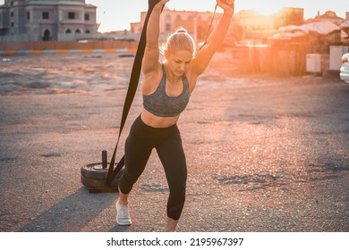 Female Athlete Pulling Weight Sled Outdoors.