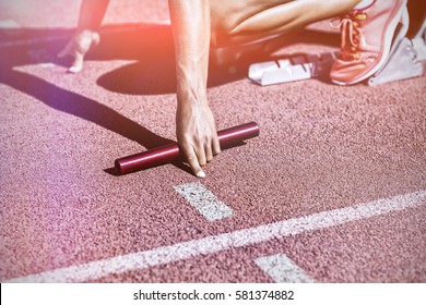 Female Athlete Ready To Start Relay Race On Running Track