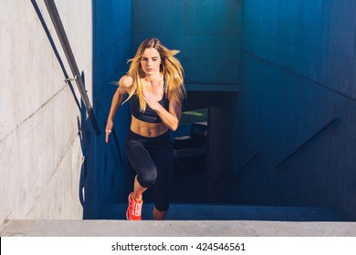 Female athlete running fast up the stairs - staircase workout - Shutterstock ID 424546561