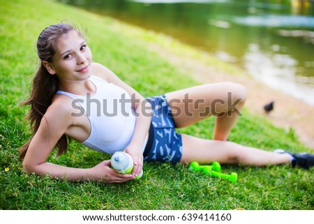 Similar – Woman in sports wear with earphones looking smartphone