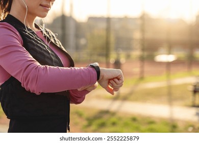 Female athlete using a smartwatch to track her fitness via a mobile app. - Powered by Shutterstock