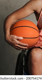 Female Athlete In A Wheelchair Holding A Basketball