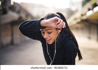 Female Athlete Wiping Sweat From Her Forehead.