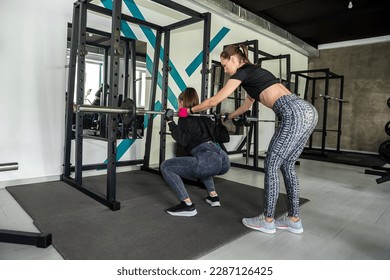  female athletic body trainer is doing a workout for a girl client. A trainer trains a girl. doing sports for the health of the body - Powered by Shutterstock