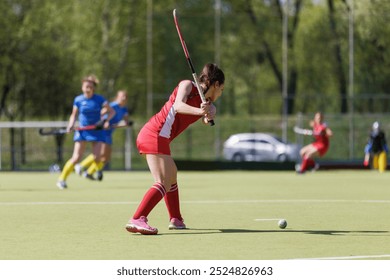 Female attacker hitting the ball in an intense field hockey match on a sunny afternoon. - Powered by Shutterstock