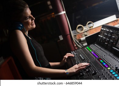 Female Audio Engineer Using Sound Mixer In Recording Studio