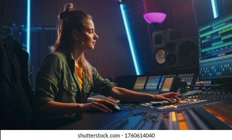 Female Audio Engineer Working In Music Recording Studio, Uses Mixing Board Create Song. Successful Girl Artist Musician Working At Control Desk. Having Fun, Smiling.