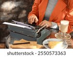 Female author using typewriter at table in street cafe, closeup