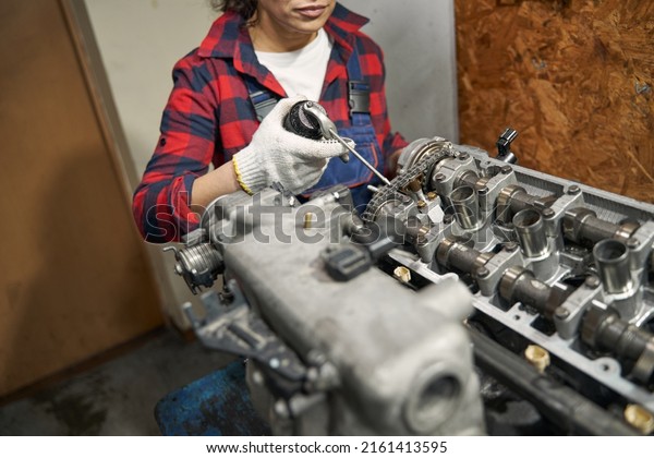 Female\
auto mechanic fixing car engine at service\
station