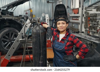 Female auto mechanic standing in car service garage - Powered by Shutterstock