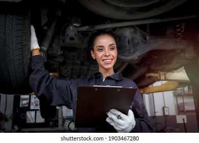 Female Auto Mechanic Work In Garage, Car Service Technician Woman Check And Repair Customer Car At Automobile Service Center, Inspecting Car Under Body And Suspension System, Vehicle Repair  Shop.