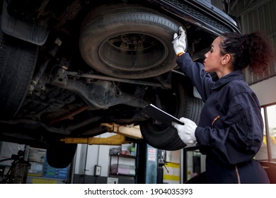 Female Auto Mechanic Work In Garage, Car Service Technician Woman Check And Repair Customer Car At Automobile Service Center, Inspecting Car Under Body And Suspension System, Vehicle Repair Shop.