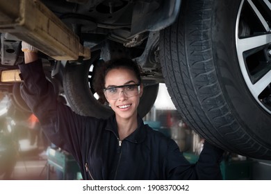 Female Auto Mechanic Work In Garage, Car Service Technician Woman Check And Repair Customer Car At Automobile Service Center, Inspecting Car Under Body And Suspension System, Vehicle Repair  Shop.