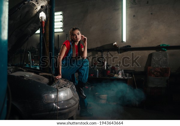 Female auto mechanic work in garage, car service\
technician woman check and repair customer car at automobile\
service center, inspecting\
car