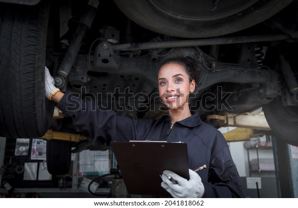 Female auto mechanic work in garage, car service\
technician woman check and repair customer’s car at automobile\
service center, inspect car underbody and suspension system,\
vehicle repair service\
shop