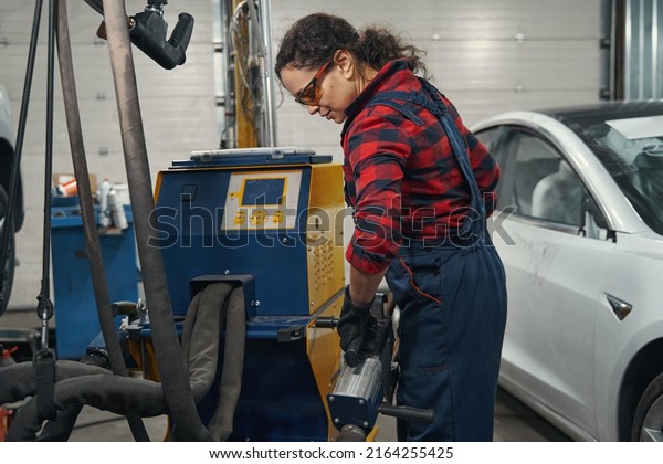 Female auto mechanic working in car repair\
service station