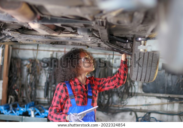 Female auto\
mechanic working at the repair\
shop.