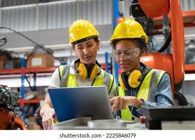 Female automation engineers in safety vest with yellow helmet using laptop for inspection new welding robot arm machine in industrial factory - Shutterstock ID 2225846079