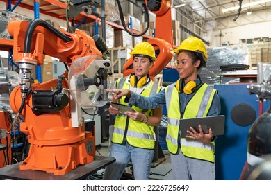 Female automation engineers in safety vest with yellow helmet using laptop for inspection new welding robot arm machine in industrial factory - Powered by Shutterstock