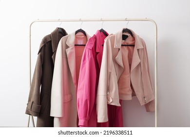 female autumn clothes on hangers  in  white room