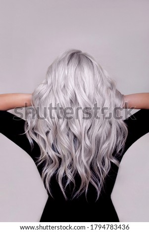 Female back with long curly blonde silver hair on grey background Stock photo © 