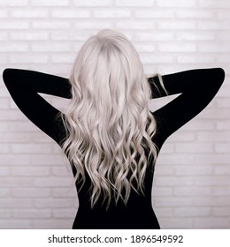 Female Back With Long, Curly, Silver Blonde Hair, On Grey Brick Wall