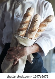 Female Baker Holding Fresh Baked French Baguette