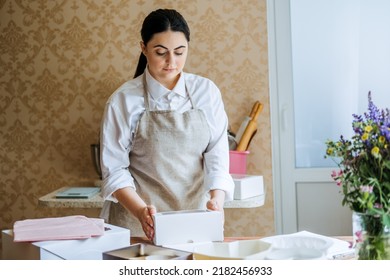 Female Baker, Pastry Chef Preparing Cake Order. Arabic Asian Woman Making Cake For Online Delivery