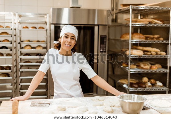female\
baker standing at workplace on baking\
manufacture
