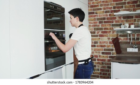 A Female Baker Turn Off The Oven On Modern Kitchen