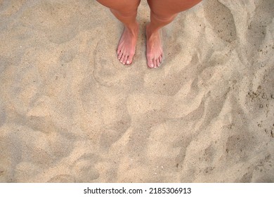 Female Bare Feet Standing On Beach Sand