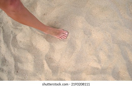 Female Bare Feet Standing On Beach Sand