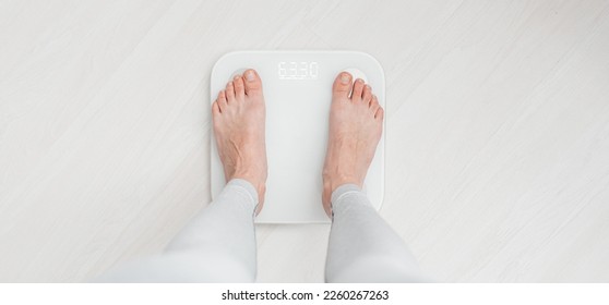 Female bare feet standing on a scales - Powered by Shutterstock