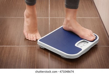 Female bare feet standing on a scales in bathroom - Powered by Shutterstock