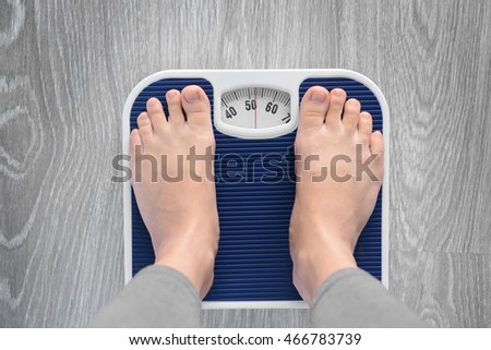 Female bare feet standing on a scales