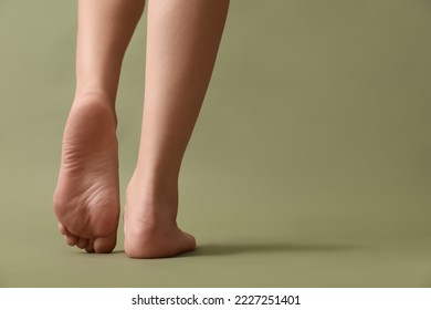 Female barefoot legs on color background