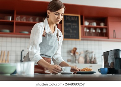 Female barista with cup of coffee on counter, preparing order for customer, young small business startup entrepreneur - Powered by Shutterstock