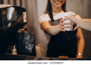 Female barista giving coffee to the customer - Powered by Shutterstock