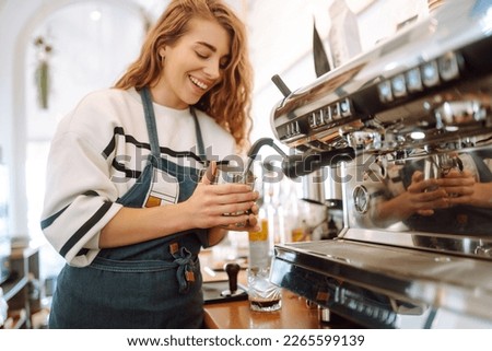 Female barista making coffee in a coffee machine. Food and drink concept.