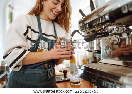 Female barista making coffee in coffee shop counter. Takeaway food.